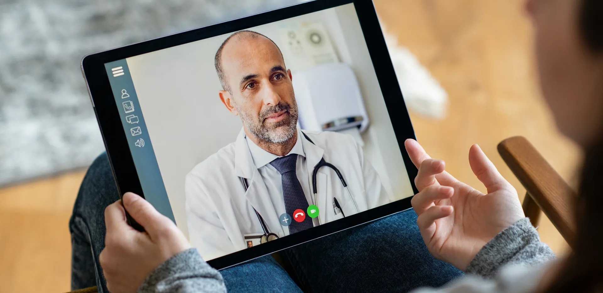 A patient speaking with their doctor via video call on a tablet.