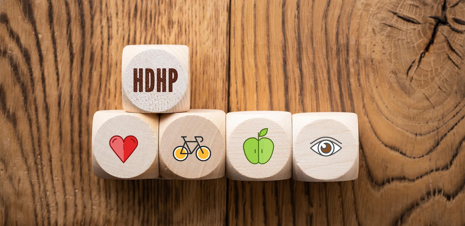 Five wooden blocks. Four have health-related icons, and one has the letters 'HDHP.'