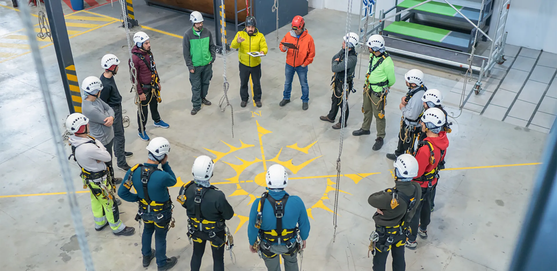 A circle of people wearing climbing gear and helmets.