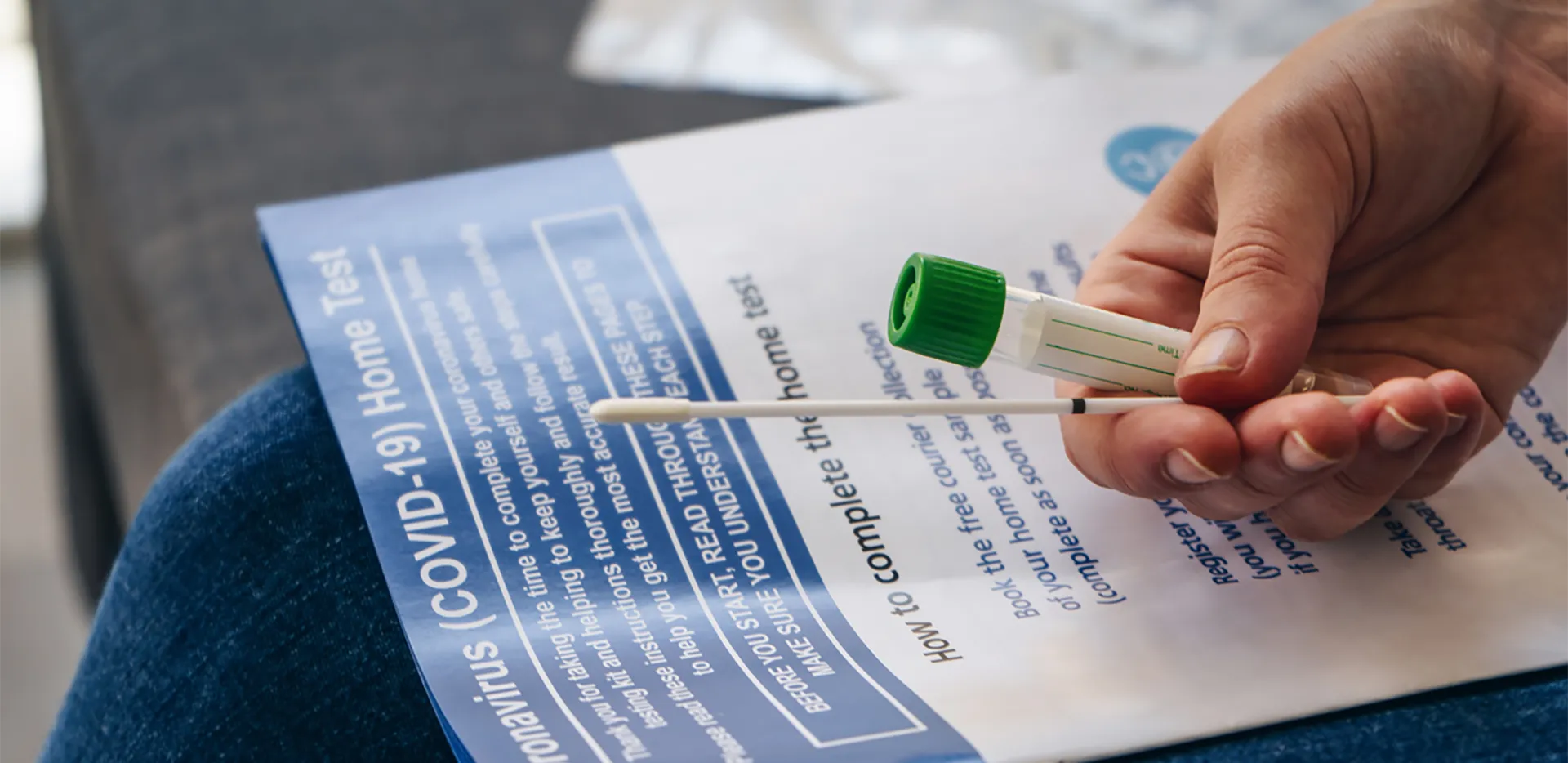Someone holding a COVID testing looking at an instruction book.