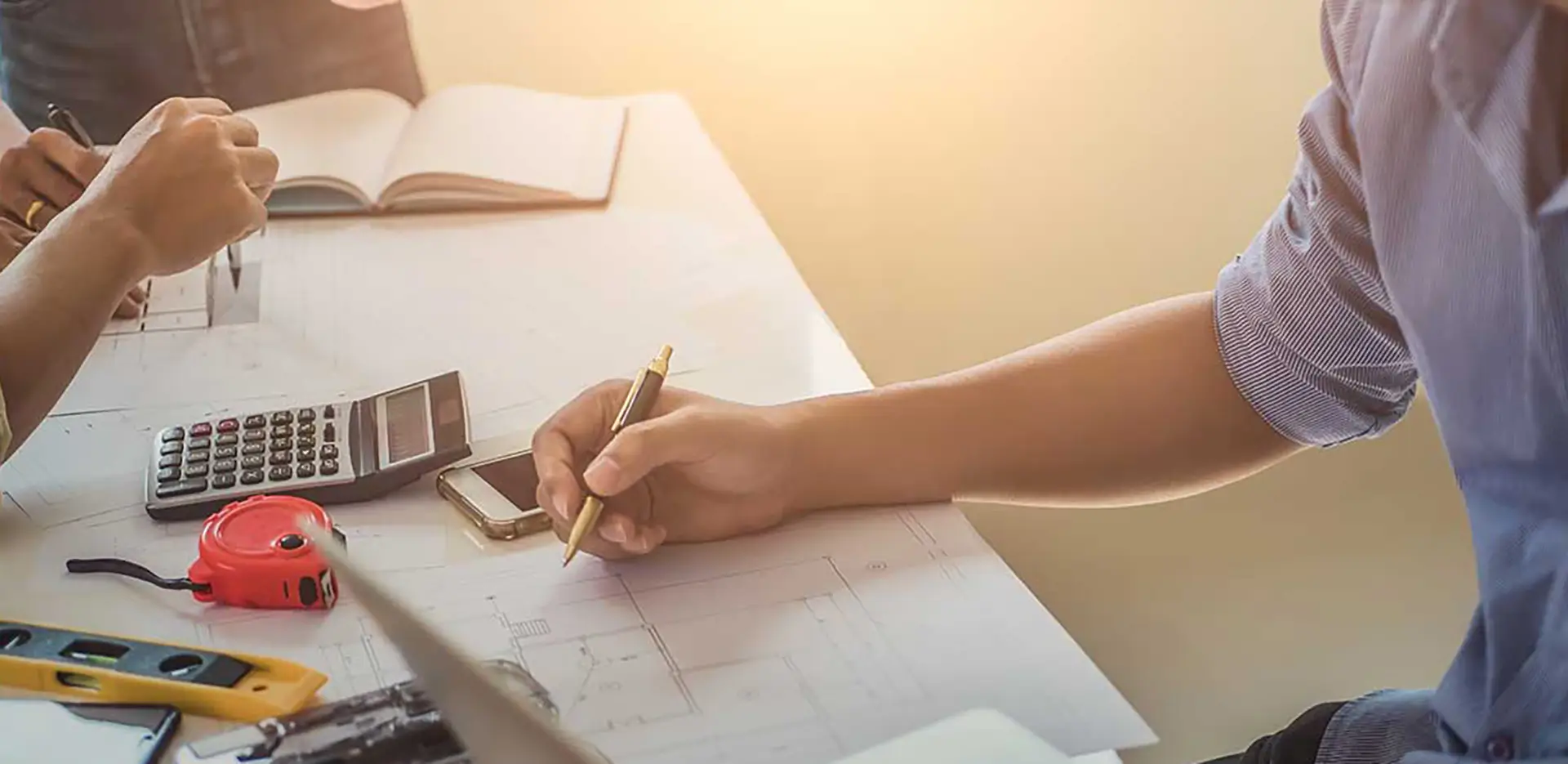 A contractor making notes on a blueprint.