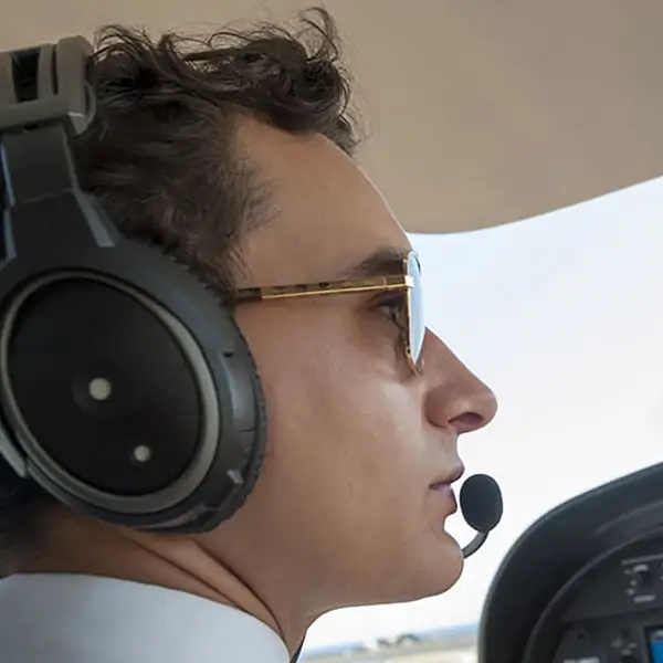 A close up of a pilot wearing a headset.
