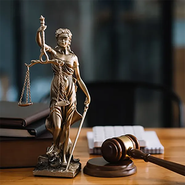 A statue of Lady Justice next to a gavel and sounding block.