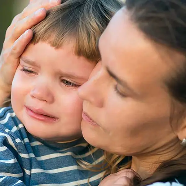 A woman holding a crying child.