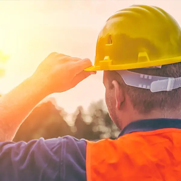 A construction worker adjusting their hard hat.