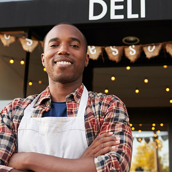 A business owner standing in front of his Deli business.