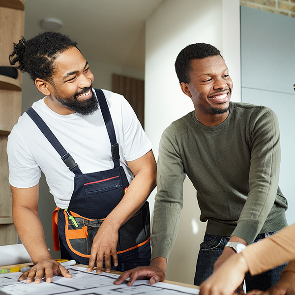 A contractor reviewing blueprints with his customers.
