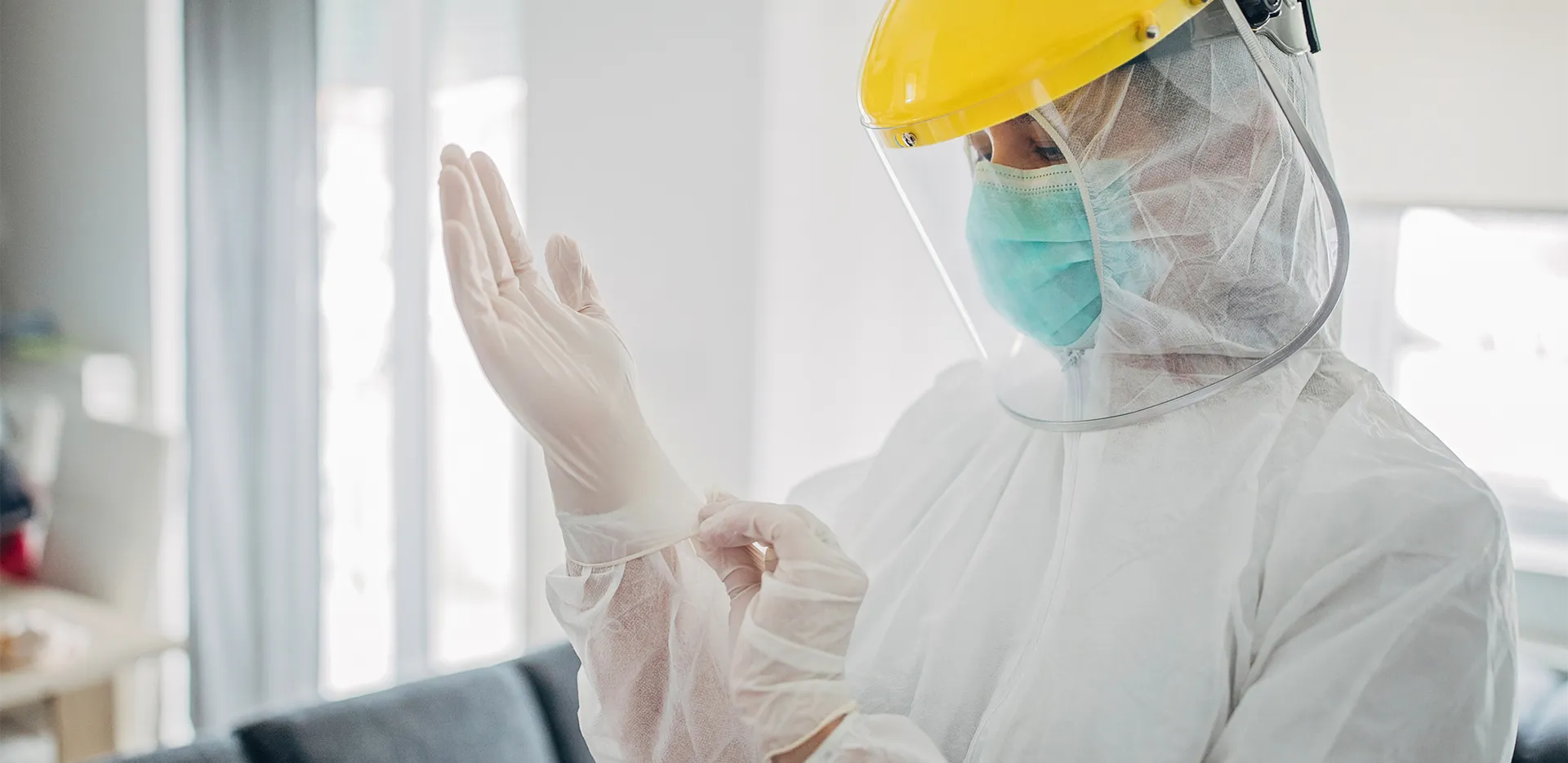 A person wearing personal protective equipment including gloves and a face mask.