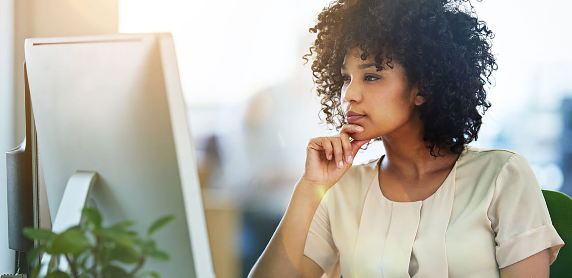 A businesswoman looking pensively at her computer.