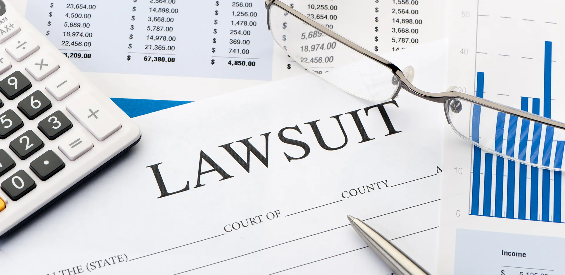 Office supplies next to a piece of paper titled 'Lawsuit.'